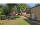 Landscaped backyard featuring a grassy lawn, a detached garage and a brick home with a wooden deck at 8178 W 64Th Ave, Arvada, CO 80004