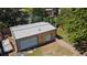 Large detached garage with a white metal roof, two garage doors and a small fenced gravel backyard at 8178 W 64Th Ave, Arvada, CO 80004
