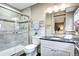 Bathroom with a glass shower door, gray tile, and modern vanity with a black granite countertop at 7877 S University Way, Centennial, CO 80122