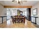 Open dining room with hardwood floors, exposed beam, and seamless flow into the living room with a fireplace at 7877 S University Way, Centennial, CO 80122