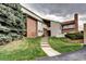 Attractive townhouse exterior features a brick facade and a well-maintained lawn with a concrete stairway at 7877 S University Way, Centennial, CO 80122
