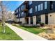 Modern apartment building featuring black wood facade, balconies, and green lawn at 2718 Pine St # 305, Boulder, CO 80302