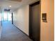 Hallway view of unit 305 with carpet flooring, black door and hardware, and overhead lighting at 2718 Pine St # 305, Boulder, CO 80302