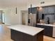 Open concept living area and modern kitchen with large island, stainless steel fridge and pendant lighting at 2718 Pine St # 305, Boulder, CO 80302