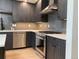 Close up of the gourmet kitchen with stainless steel appliances, grey cabinets, and tile backsplash at 2718 Pine St # 305, Boulder, CO 80302