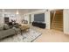 Finished basement featuring a recreation area with TV, sectional, and stairs leading to the main floor at 9241 Knox Ct, Westminster, CO 80031