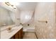 A bathroom features a white vanity and sink, toilet, and tub with white patterned wallpaper at 9241 Knox Ct, Westminster, CO 80031