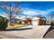 Spacious brick home with a long driveway, attached garage, and mature trees at 9241 Knox Ct, Westminster, CO 80031