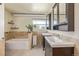 Bathroom featuring double sinks, cabinetry, and a bathtub with tile surround at 576 S Tabor St, Elizabeth, CO 80107
