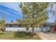 Charming single-story home featuring a landscaped front yard and a red front door under a bright blue sky at 576 S Tabor St, Elizabeth, CO 80107