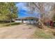 A quaint, light blue single-story home featuring mature trees and ample parking on a sunny day at 576 S Tabor St, Elizabeth, CO 80107