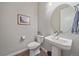 Small powder room with pedestal sink and toilet at 22537 E Swallow Pl, Aurora, CO 80016