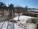 Fenced backyard featuring a winter landscape, and views of mature trees and neighboring homes at 3212 S Kirk Way, Aurora, CO 80013