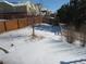 Fenced backyard featuring a snow-covered landscape, a mix of wood and white fencing at 3212 S Kirk Way, Aurora, CO 80013