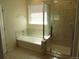 Bathroom featuring a tub with tile surround, a glass shower, and neutral tones for a spa-like feel at 3212 S Kirk Way, Aurora, CO 80013