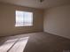 A sunlit carpeted bedroom with a large window at 3212 S Kirk Way, Aurora, CO 80013