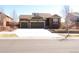 Inviting home featuring a two-car garage, a well-maintained lawn, and classic architectural details at 3212 S Kirk Way, Aurora, CO 80013