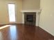 Cozy living area featuring a fireplace with mantle, hardwood flooring, and natural light at 3212 S Kirk Way, Aurora, CO 80013
