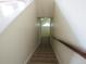 Carpeted stairwell featuring natural wood handrail and entry to naturally lit room at 3212 S Kirk Way, Aurora, CO 80013