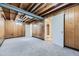 Unfinished basement with wood paneled walls, carpeted floor and exposed beams and ductwork at 16293 E Brown Pl, Aurora, CO 80013