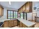 Cozy kitchen featuring wood cabinets, tile countertops, stainless steel dishwasher, and natural light at 16293 E Brown Pl, Aurora, CO 80013