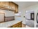 Open kitchen layout with wood cabinets, tile countertops, and view to living room at 16293 E Brown Pl, Aurora, CO 80013