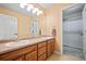 Bathroom with double vanity, wood cabinets, and a walk-in shower at 1535 Plowman Dr, Monument, CO 80132