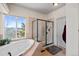 Bathroom with soaking tub, walk-in shower, and large window at 1535 Plowman Dr, Monument, CO 80132