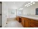 Bathroom featuring double sinks, a tub, tile flooring, and natural wood cabinetry at 11969 E Lake Cir, Greenwood Village, CO 80111