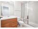 Bathroom with wood cabinets, white sink, tile flooring, and glass enclosed shower at 11969 E Lake Cir, Greenwood Village, CO 80111