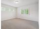 Bright bedroom with neutral carpet, three windows, and charming shuttered windows at 11969 E Lake Cir, Greenwood Village, CO 80111