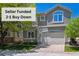 Charming two-story home with a neutral-toned exterior, arched window, attached garage, and well-maintained lawn at 11969 E Lake Cir, Greenwood Village, CO 80111