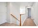 Bright hallway featuring clean white walls and an oak and white staircase at 11969 E Lake Cir, Greenwood Village, CO 80111