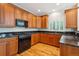 Modern kitchen with wood cabinets, granite counters, and stainless appliances at 11969 E Lake Cir, Greenwood Village, CO 80111