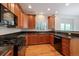 Modern kitchen with wood cabinets, black countertops, and stainless steel appliances at 11969 E Lake Cir, Greenwood Village, CO 80111