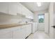 Well-lit laundry room featuring white cabinets, countertop, sink, washer, and dryer at 11969 E Lake Cir, Greenwood Village, CO 80111