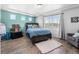 Bright bedroom with wood-look floors, teal accent wall, and abundant natural light at 4405 Walden Ct, Denver, CO 80249