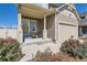 Welcoming front porch with seating, complemented by beautiful flowerbeds and a well-manicured lawn at 4405 Walden Ct, Denver, CO 80249