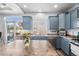 Bright kitchen with blue cabinets, stainless steel appliances, and a sliding door to the outdoor deck at 4405 Walden Ct, Denver, CO 80249
