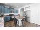 Stylish kitchen featuring blue cabinets, stainless steel appliances, and a central island with seating at 4405 Walden Ct, Denver, CO 80249