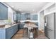 Stylish kitchen featuring blue cabinets, stainless steel appliances, and a central island with seating at 4405 Walden Ct, Denver, CO 80249