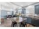 Open concept kitchen with blue cabinets, flowing into a living area with comfortable seating and natural light at 4405 Walden Ct, Denver, CO 80249