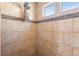Close up view of a well-maintained tile shower with built-in shelving and mosaic details at 4405 Walden Ct, Denver, CO 80249