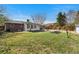 Grassy backyard with a patio, gardening beds, privacy fence, and mature trees at 3002 S Fenton St, Denver, CO 80227