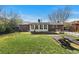 Well-maintained backyard with mature trees, garden beds, and outdoor seating area at 3002 S Fenton St, Denver, CO 80227