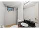 Well-lit bathroom with a modern vanity, black countertop, and combined shower and tub at 3002 S Fenton St, Denver, CO 80227