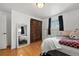 The bedroom features a large mirror, ample windows, and hardwood floors at 3002 S Fenton St, Denver, CO 80227