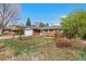 Charming brick home with manicured lawn, mature trees, and attached two-car garage at 3002 S Fenton St, Denver, CO 80227