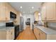 Modern kitchen with light wood cabinets, stainless steel appliances, a functional layout, and hardwood floors at 3002 S Fenton St, Denver, CO 80227