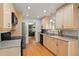 Bright kitchen featuring wood floors, stainless appliances, light wood cabinets, and granite countertops at 3002 S Fenton St, Denver, CO 80227